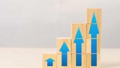 Blocks with upward arrows representing growth, symbolizing how to increase your chances for car loan approval.
