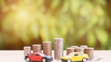 Toy cars and stacked coins symbolizing Minimum Salary for a Car Loan in the Philippines.