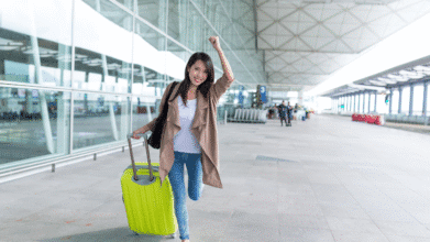 Excited woman arriving at the airport with luggage, reuniting for Mother's Day 2025 celebration
