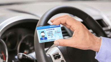 Hand holding a driver’s license inside a car