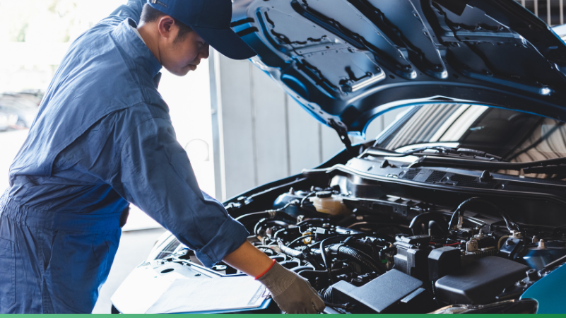 Mechanic inspecting engine as part of maintenance after buying a secondhand car.