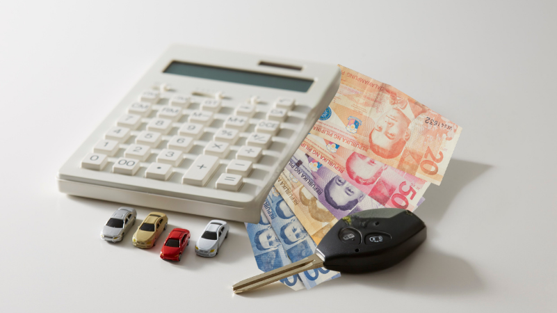 Calculator, car key, and cash symbolizing budget planning for buying a secondhand car.